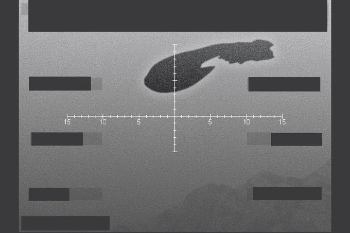 A black and white surveillance photo of the silhouette of a Covenant cruiser flying low over mountains