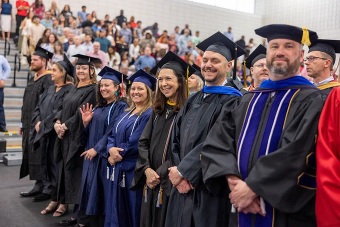 Wake Tech faculty smile during graduation.