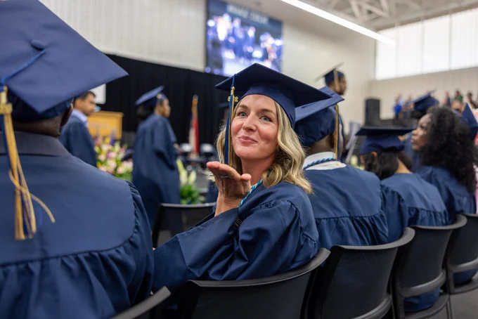 A Wake Tech graduate blows a kiss during commencement.