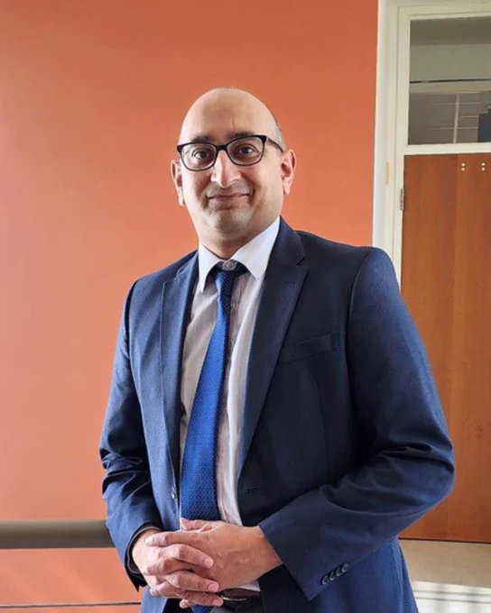 Shiley Eye faculty Shyamanga Borooah, MBBS, FRCP(Edin) FRCSEd, FRCOphth, PhD standing in front of blank wall. 
