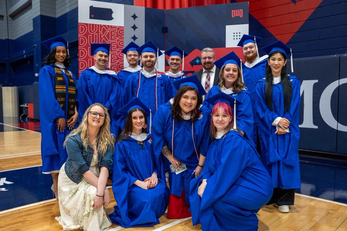 Graduates in front of step and repeat.