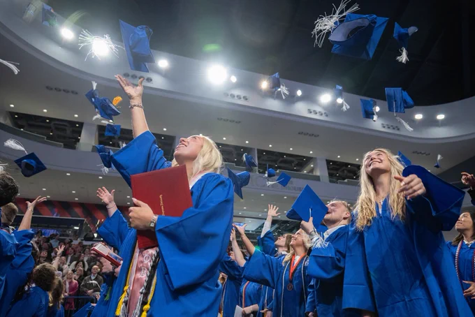 Graduates tossing caps.