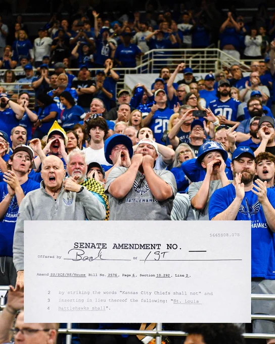 A passionate group of fans cheering loudly at a sports event, wearing blue shirts with Battlehawks logos. There is a humorous text overlay of a mock Senate Amendment about the Battlehawks.