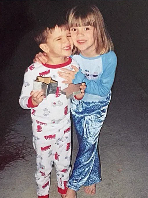 Two children in pajamas share a joyful hug. Their expressions are happy and carefree, reflecting a playful nighttime moment.