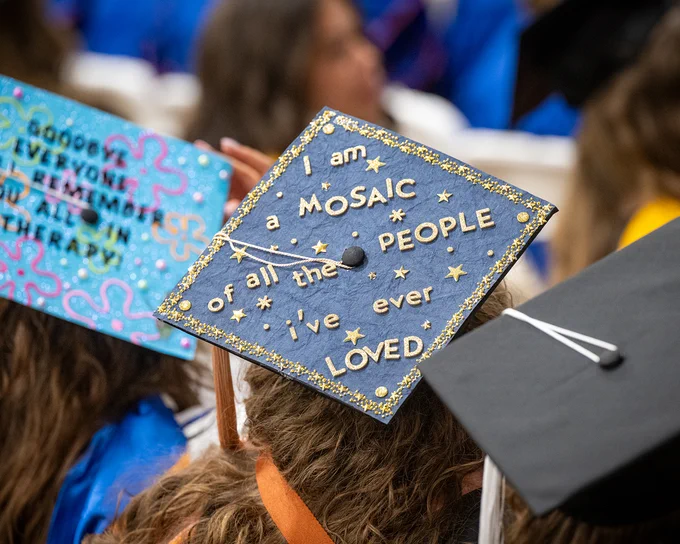 Close up of a decorated graduation cap that says “I am a mosaic of all the people I’ve ever loved.” 

