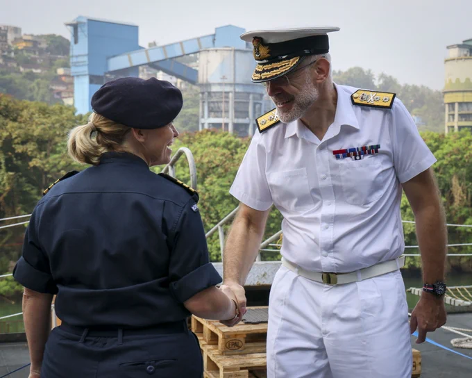Military personnel shake hands.