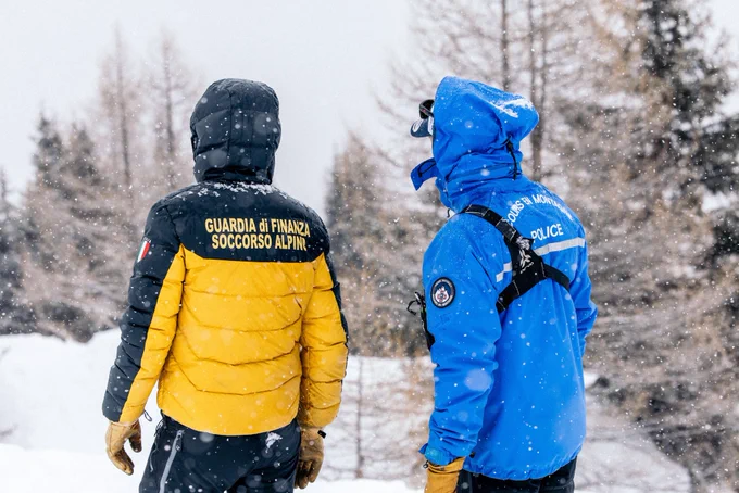 Photographie d’un policier français et d’un policier italien de dos sous la neige.