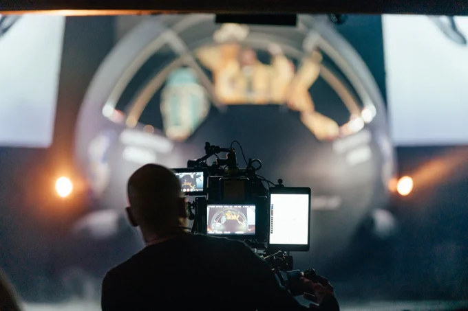A camera focuses on a large plane on a stage with people sat in it.