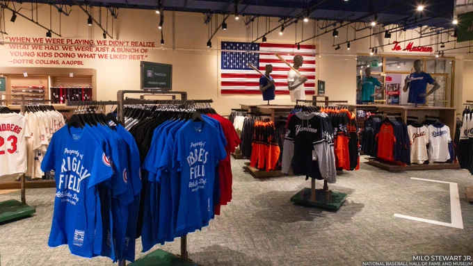 T-shirts on display in the Museum store facing a large United States flag made of red, white and blue painted bats. (Milo Stewart Jr./National Baseball Hall of Fame and Museum)