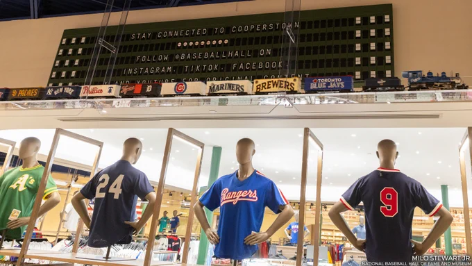 Mannequins model jerseys as a model train passes overhead. A split-flap board reminiscent of a train station encourages you to follow us on all social media channels. (Milo Stewart Jr./National Baseball Hall of Fame and Museum)
