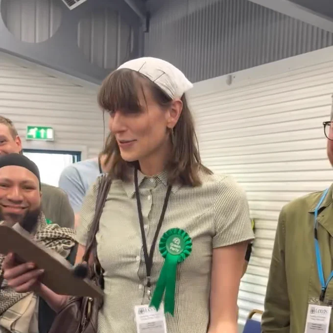 Mothin Ali grinning beside Eden Hills giving her victory speech