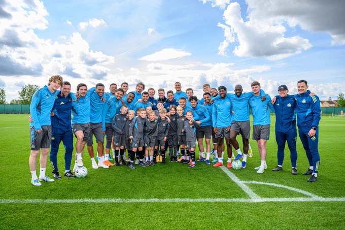 The first team squad and staff pictured with the Under-8s players at our training ground.