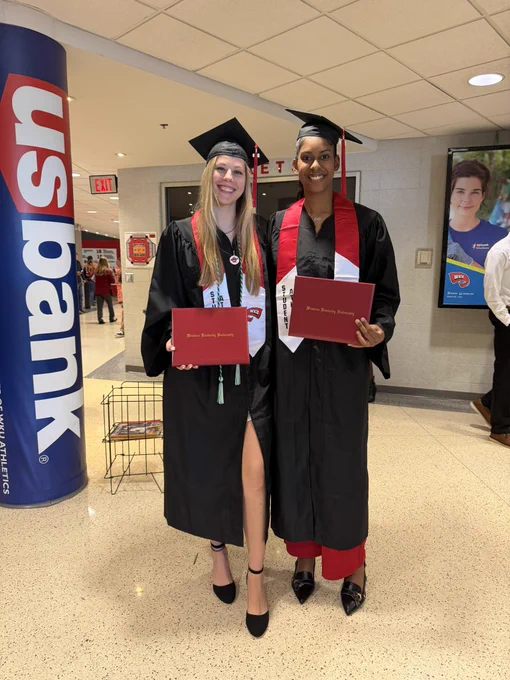 Zsofia Telegdy and Jeniffer Silva pose in cap and gown at WKU graduation
