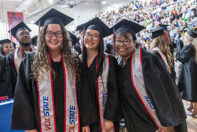 Three new graduates smile for the camera during the event.