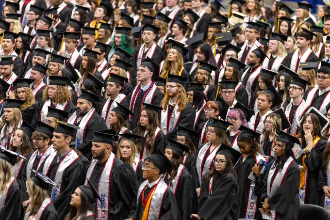 A sea of graduates are standing as they celebrate the ceremony.