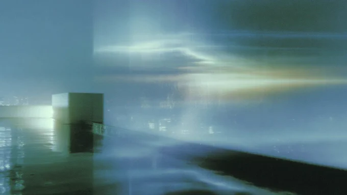 Fading architectural traces and reflected city light merging into a soft blue-green field of rain and signal