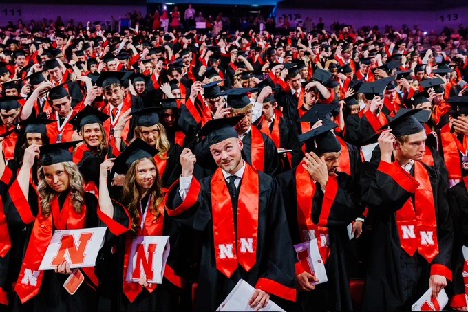 Undergraduates smile as the turn their tassel at the end of the commencement ceremony
