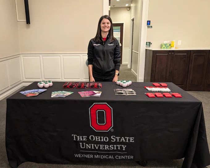 Chrissie Sediqe, MPH, behind the booth for Ohio State Ophthalmology at the Circle of Excellence event