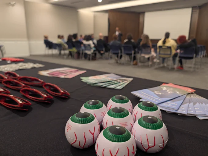 close up image of giveaway items on the Ohio State Ophthalmology booth with the event attendees in the background