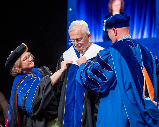 Bruce Newcomb receiving an Honorary Doctor of Laws from Boise State University during the Spring 2026 Commencement ceremony. 