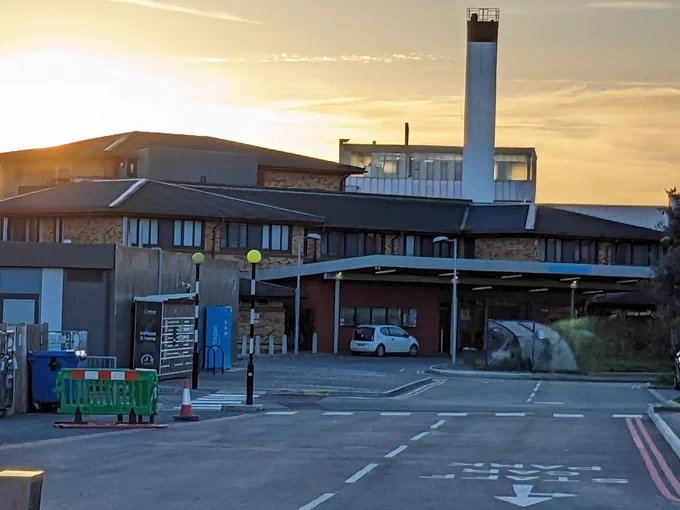Photo of The East Surrey hospital with the sun setting behind the building.