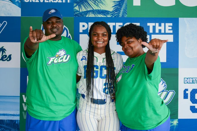 a photo of a family smiling wearing fgcu merch