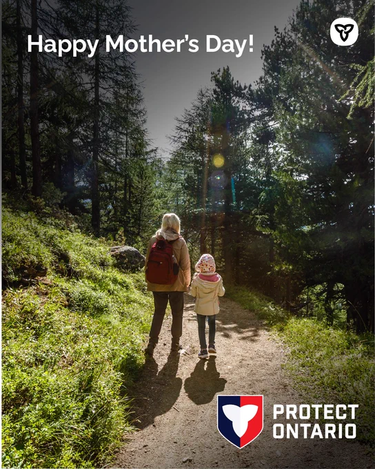A mother and child walking on a path in the forest.