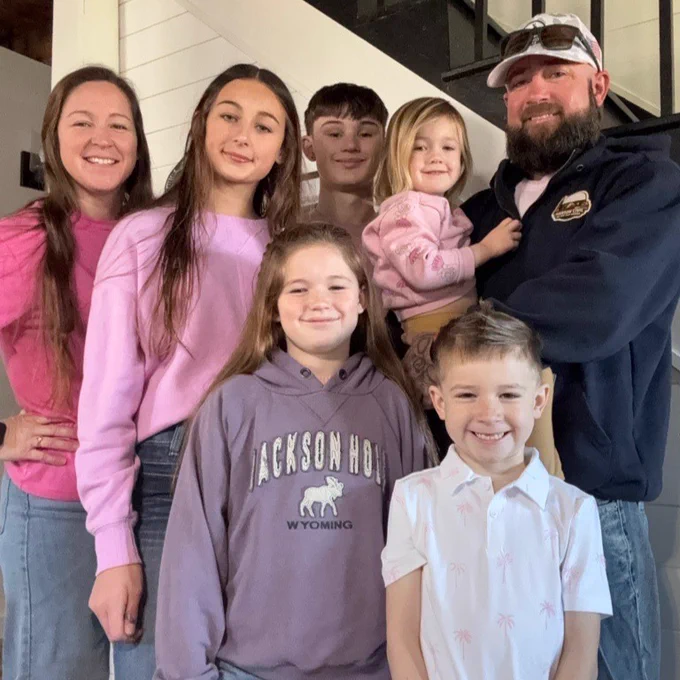 A family of seven smiles and poses for the camera. 