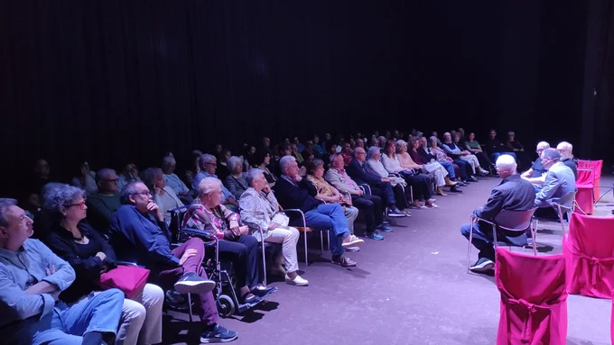 Un moment de l'acte, en què van assistir un centenar de persones. El públic es veu de primer terme fins al final, repartit en diferents files. 