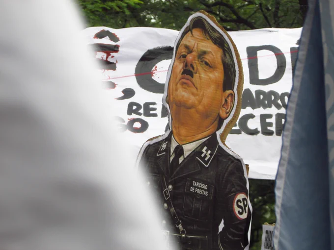 Um cartaz com o rosto de Tarcísio de Freitas, governador do Estado de São Paulo, vestindo um uniforme nazista. A suástica foi substituída pela sigla "SP". Créditos: Gabriel Albuquerque