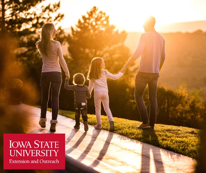 family walking outside on a trail on a sunny evening