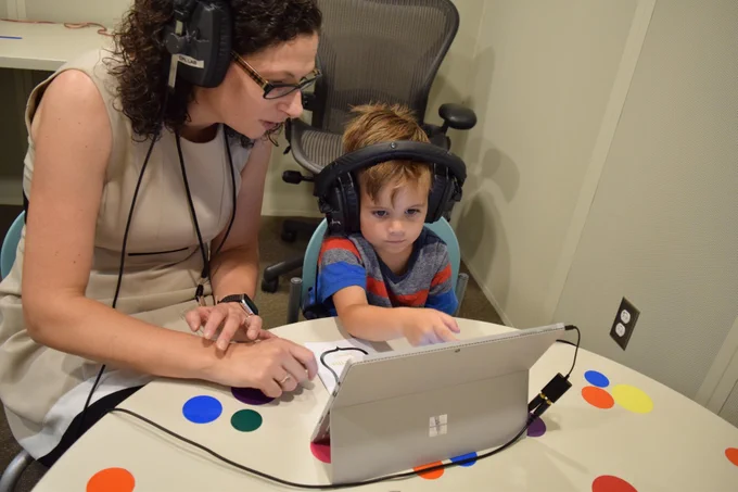 woman giving a child a hearing test