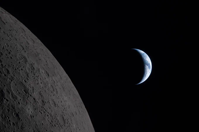 This image was captured during the lunar flyby portion of the Artemis II mission on April 6, 2026. Earth is in a crescent phase, with sunlight coming from the right. The dark portion of Earth is experiencing nighttime. On Earth\u2019s day side, swirling clouds are visible over muted blue in the Australia and Oceania region. There are small indentations on the Moon\u2019s rugged surface. Credit: NASA