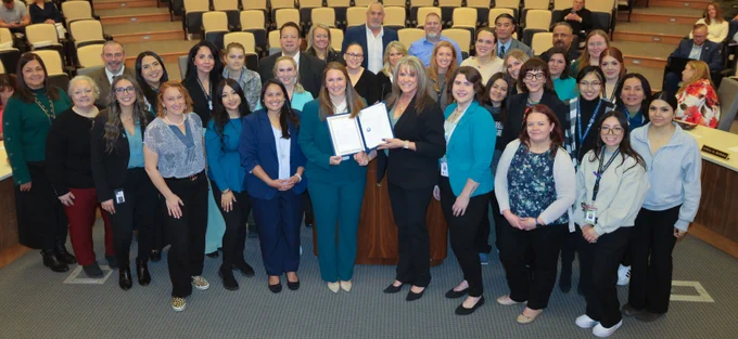 Picture of Adams County leaders standing around the proclamation. 