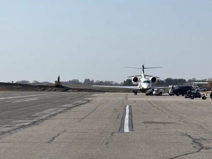 A plane taxis on a runway on a clear, sunny day.