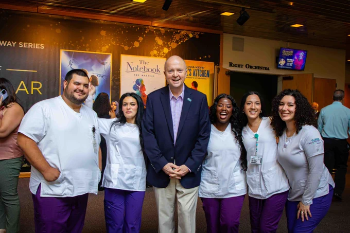 Dr. Allbritten stands between five FSW nursing students in the BB Mann lobby.