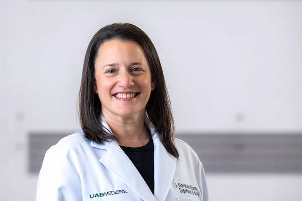 Jacqueline Garonzik Wang, M.D., Ph.D., stands in front of a white background.