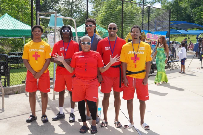 Six lifeguards from DC’s Department of Parks and Recreation standing in a line smiling at Langdon Park Pool.
