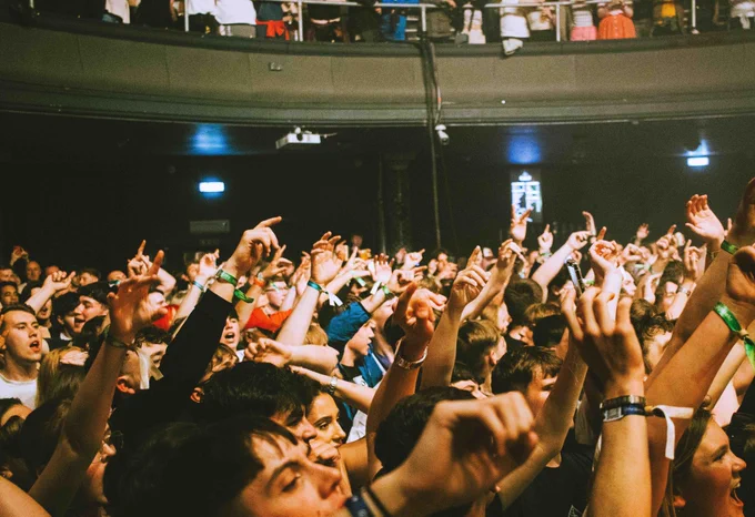 A crowd of people in a concert venue. 