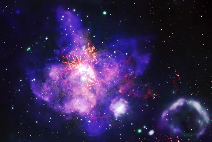 This composite image contains the deepest X-ray image ever made of the spectacular star forming region called 30 Doradus. By combining X-ray data from NASA’s Chandra X-ray Observatory (blue and green) with optical data from NASA’s Hubble Space Telescope (yellow) and radio data from the Atacama Large Millimeter/submillimeter Array (orange), this stellar arrangement comes alive. Credit: X-ray: NASA/CXC/Penn State Univ./L. Townsley et al.; Infrared: NASA/JPL-CalTech/SST; Optical: NASA/STScI/HST; Radio: ESO/NAOJ/NRAO/ALMA; Image Processing: NASA/CXC/SAO/J. Schmidt, N. Wolk, K. Arcand 