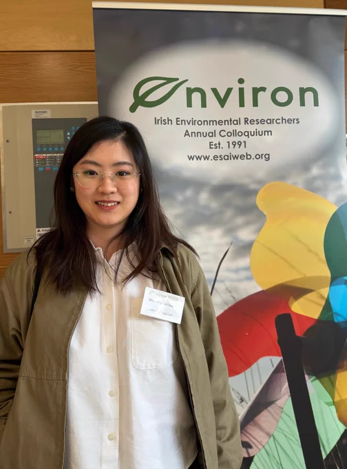 Jingrou stands beside the colourful poster of Environ