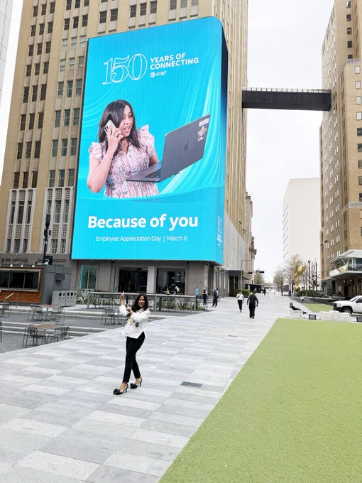 Ashmy in front of the AT&T Discovery District media wall displaying an ad that she appears in