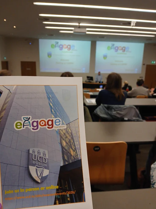A pamphlet in the foreground and the presenter screens in the background