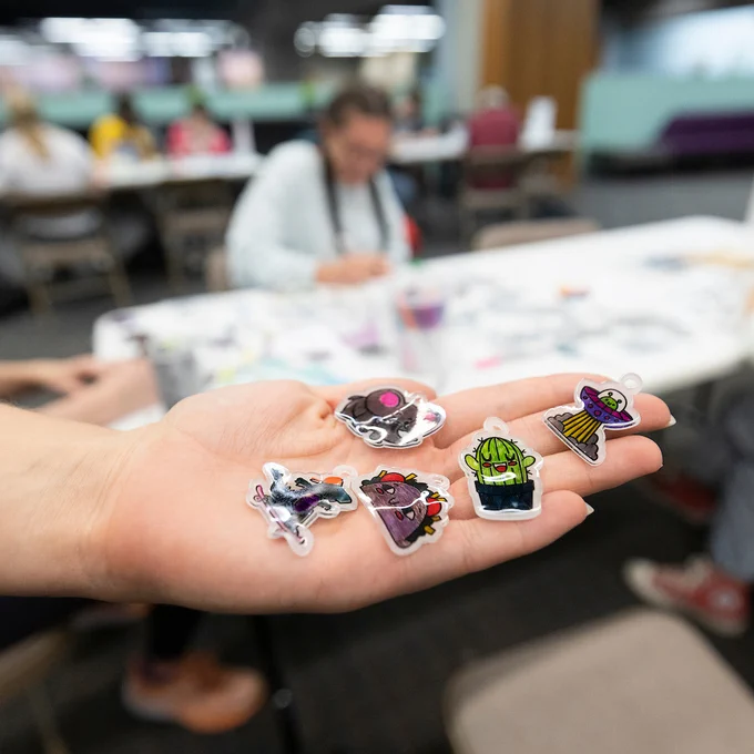 a hand holding shrinky dink stickers.