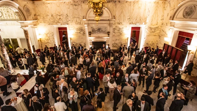 A crowd mills about at a cocktail hour