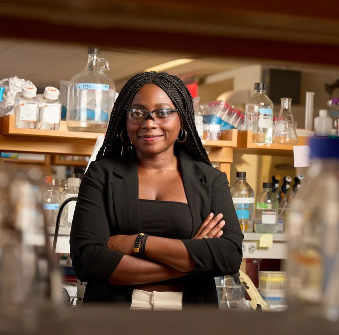 Janina Ojeiduma ’27 stands in the bio lab surrounded by lab equipment