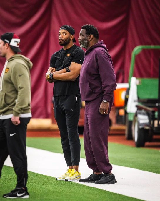 Photo of Doug and D.J. Williams at a Commanders practice. They are both wearing Commanders gear.