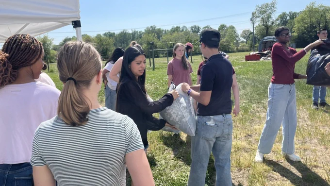 volunteers load bagged clothing drive items into the vehicle picking up donations
