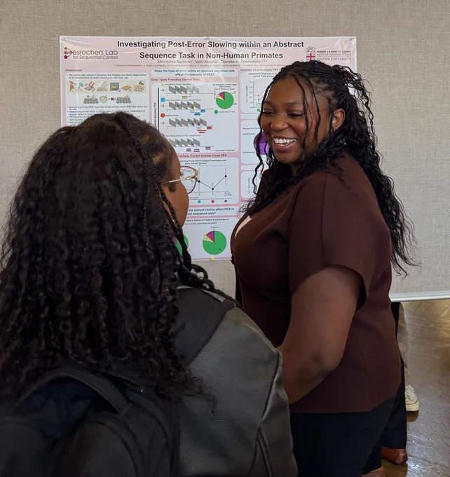 Mmesoma in front of her poster presenting to a person who has their back to the camera