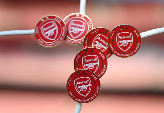 A cluster of the 2025/26 exclusive AWFC pin badge, pinned to the Emirates goal net